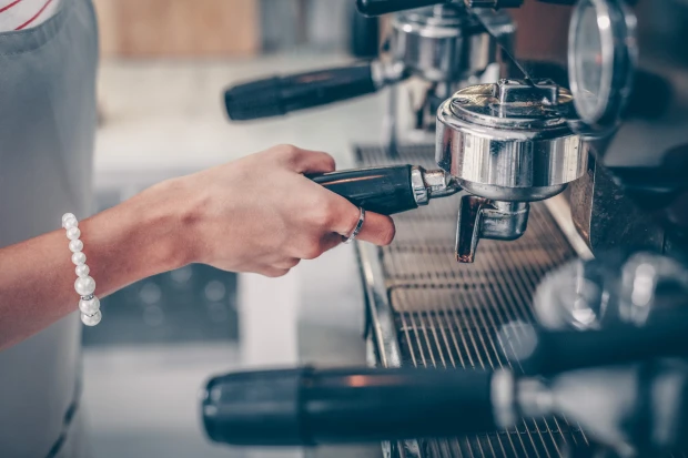 Vrouw bedient koffiezetapparaat